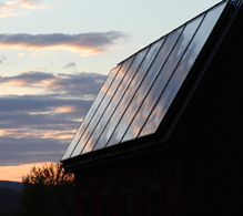 barn w solar panels reflecting the sunset